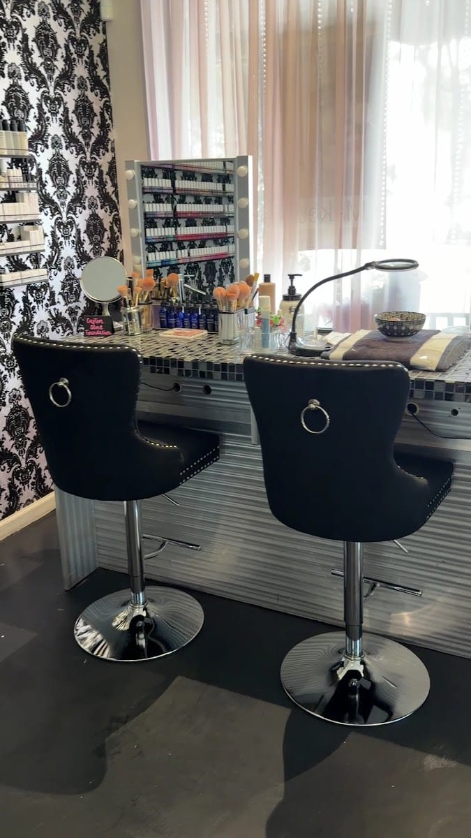 The makeup bar at Bella Reina Spa — tufted chairs and damask wall